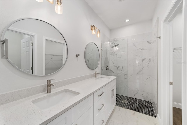 bathroom featuring tiled shower and vanity