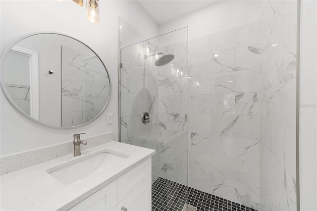 bathroom with a tile shower and vanity