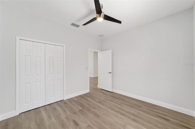 unfurnished bedroom with ceiling fan, a closet, and light wood-type flooring