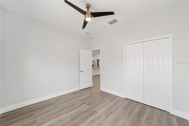 unfurnished bedroom with ceiling fan, light hardwood / wood-style floors, and a closet