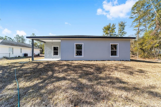 rear view of property with a yard, central AC, and a patio area