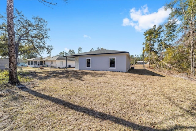 rear view of house featuring a yard