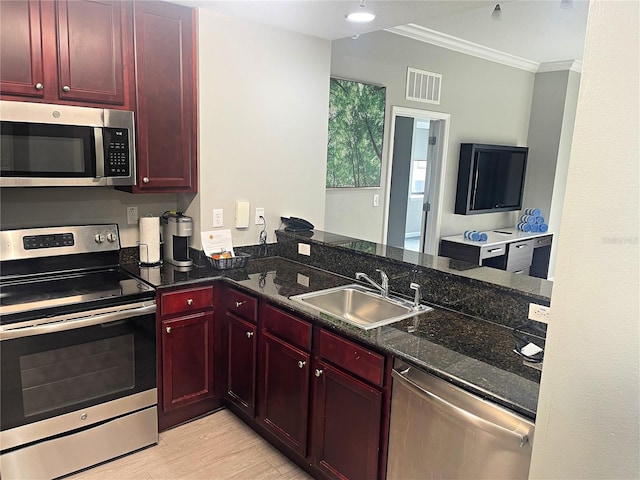 kitchen with sink, light hardwood / wood-style flooring, dark stone countertops, ornamental molding, and appliances with stainless steel finishes