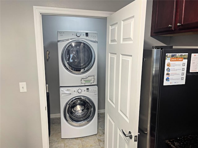 washroom featuring stacked washer and dryer and light tile patterned floors