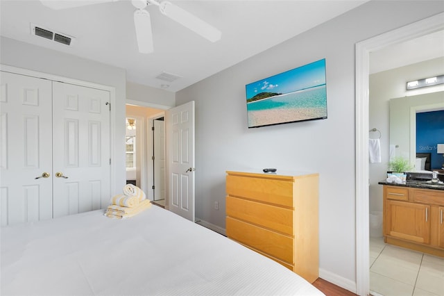 bedroom with ceiling fan, ensuite bathroom, sink, and a closet