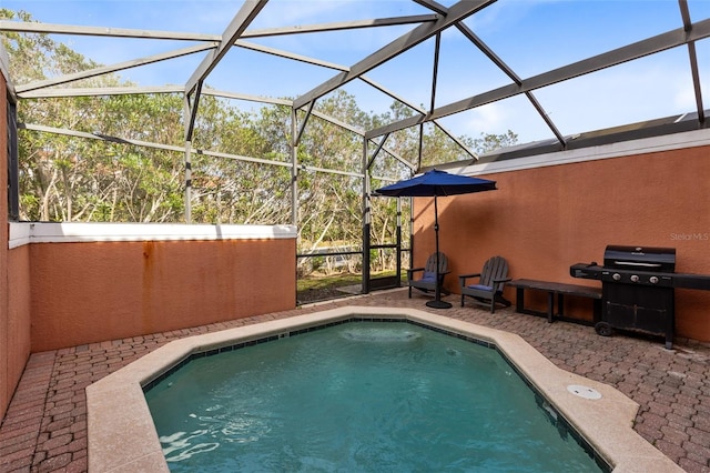 view of swimming pool featuring grilling area, a patio, and glass enclosure