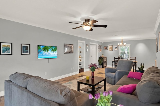 living room featuring ornamental molding, ceiling fan with notable chandelier, and built in shelves