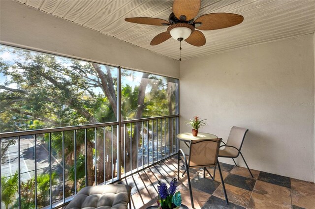 unfurnished sunroom with ceiling fan