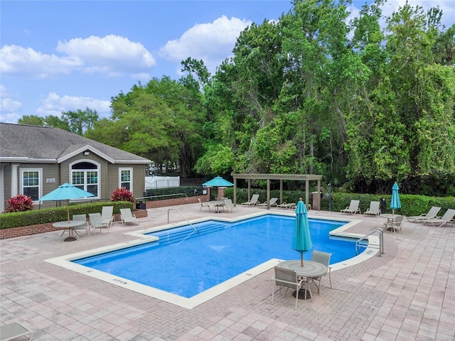 view of swimming pool with a patio and a pergola