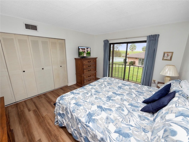 bedroom featuring hardwood / wood-style flooring, access to outside, a closet, and a textured ceiling