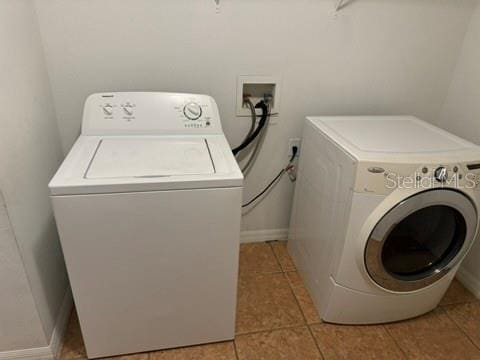 clothes washing area with light tile patterned flooring and washing machine and clothes dryer