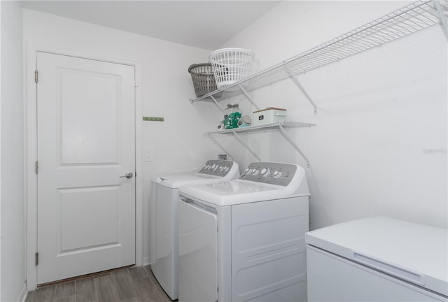 clothes washing area with dark hardwood / wood-style floors and washing machine and clothes dryer