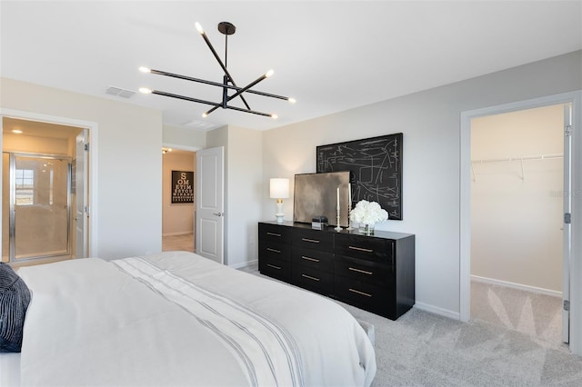 bedroom featuring connected bathroom, a spacious closet, light colored carpet, a notable chandelier, and a closet