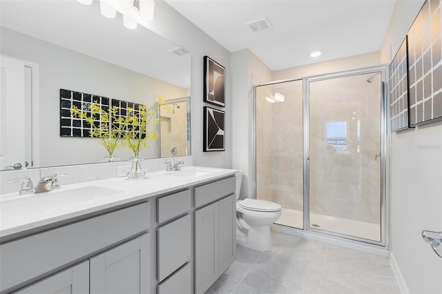 bathroom with vanity, toilet, and a shower with door