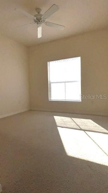 spare room featuring carpet floors and ceiling fan