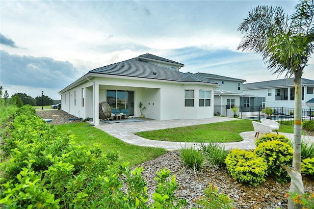 rear view of house with a patio area and a lawn