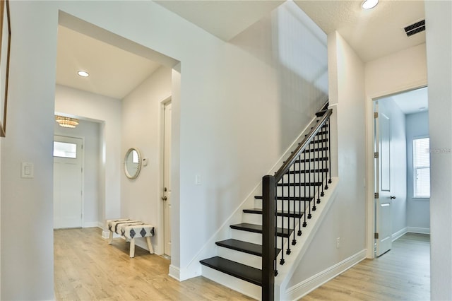 stairs featuring wood-type flooring and a healthy amount of sunlight