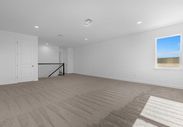 carpeted spare room featuring a textured ceiling