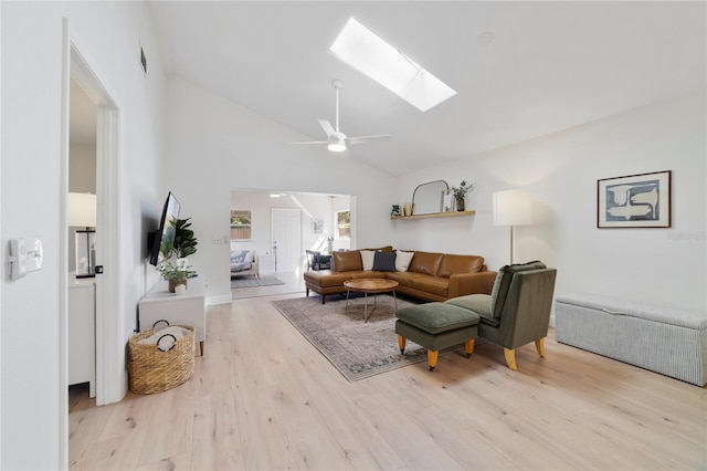 living room with light hardwood / wood-style flooring, a skylight, high vaulted ceiling, and ceiling fan