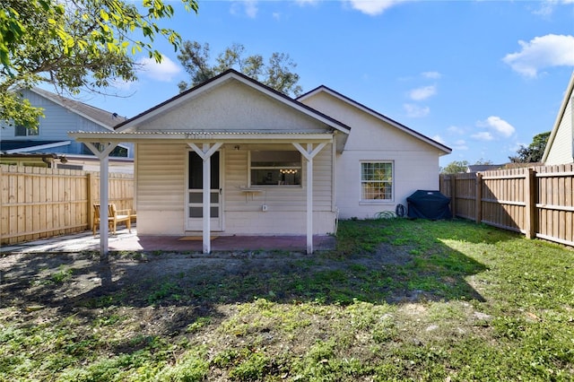 rear view of house featuring a patio and a yard