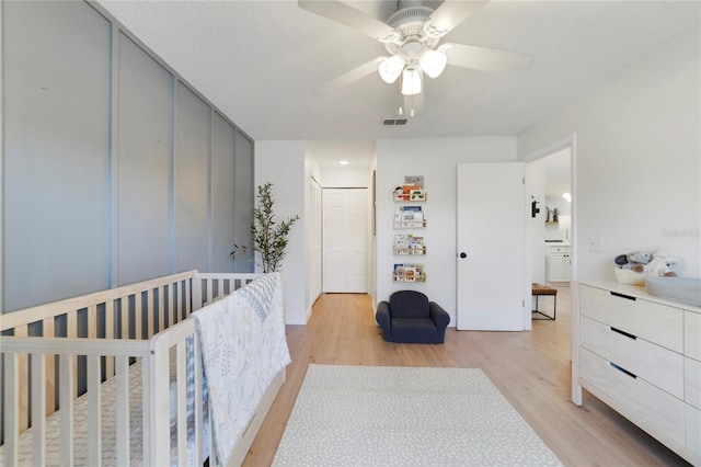 bedroom with ceiling fan, a textured ceiling, and light wood-type flooring