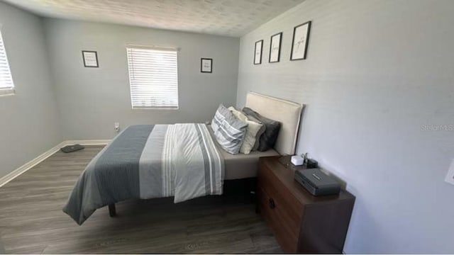 bedroom featuring dark hardwood / wood-style flooring and a textured ceiling