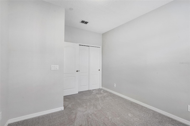 unfurnished bedroom with a closet, carpet floors, and a textured ceiling