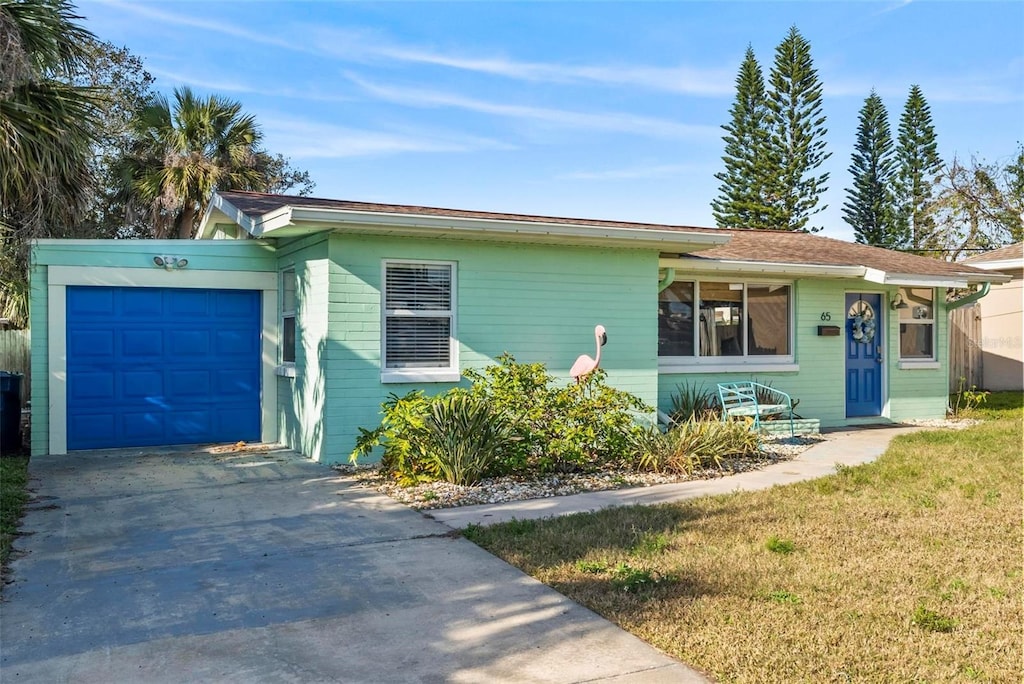 single story home with a garage and a front lawn