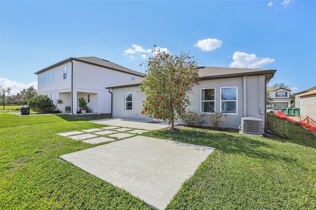 back of property with a yard, cooling unit, and a patio area