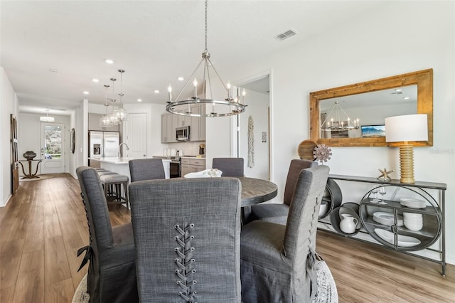 dining area featuring hardwood / wood-style flooring and a chandelier