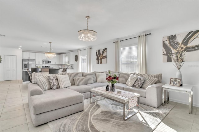 tiled living room with a notable chandelier