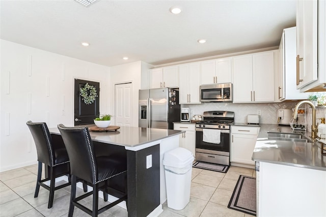 kitchen featuring white cabinetry, stainless steel appliances, and a center island