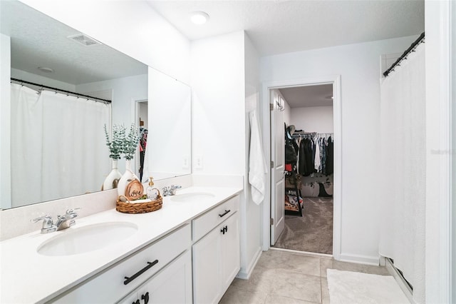 bathroom featuring tile patterned flooring, vanity, and a textured ceiling