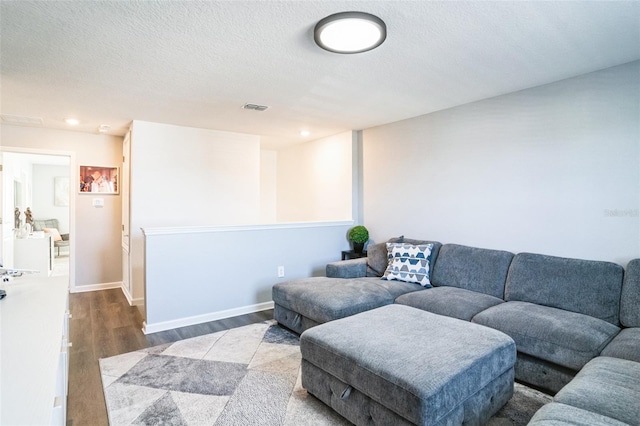 living room featuring wood-type flooring and a textured ceiling