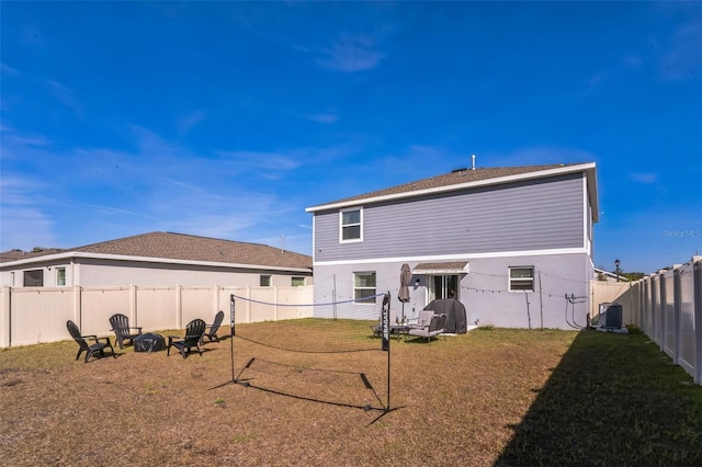 rear view of house featuring a yard, central air condition unit, and an outdoor fire pit