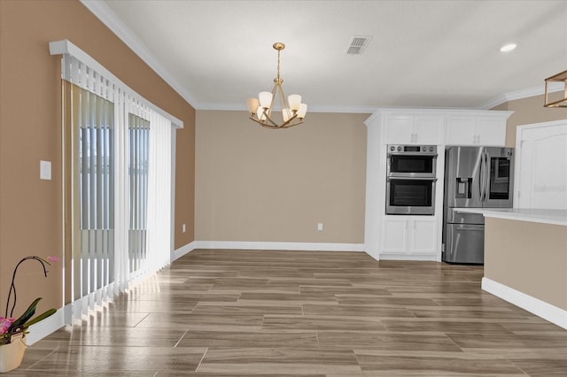 kitchen featuring white cabinetry, appliances with stainless steel finishes, ornamental molding, and light hardwood / wood-style flooring