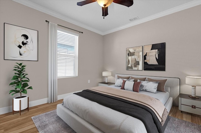 bedroom featuring ornamental molding, ceiling fan, and light hardwood / wood-style flooring