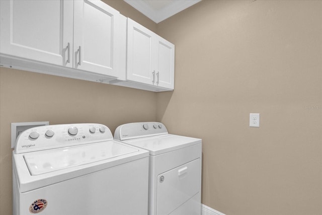 clothes washing area featuring cabinets and washing machine and clothes dryer