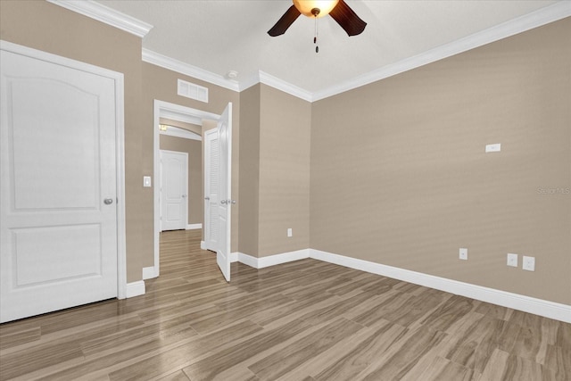 empty room featuring ceiling fan, ornamental molding, and light hardwood / wood-style flooring