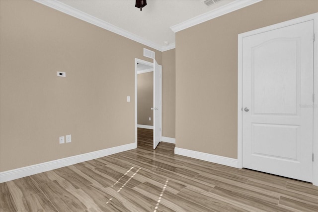 spare room with crown molding, ceiling fan, and light wood-type flooring