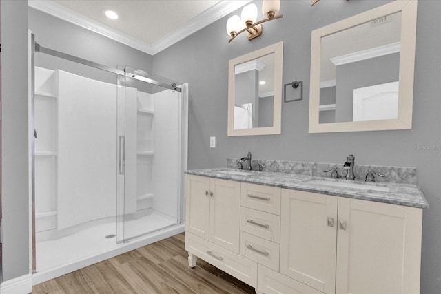 bathroom featuring wood-type flooring, vanity, crown molding, and walk in shower