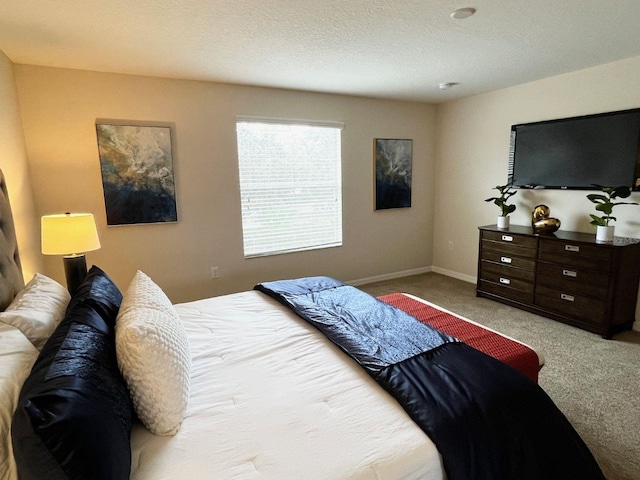 bedroom with light colored carpet and a textured ceiling