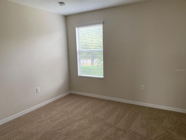 carpeted empty room with a textured ceiling