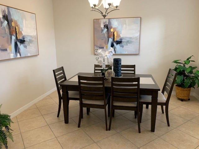 dining area with light tile patterned floors and a chandelier