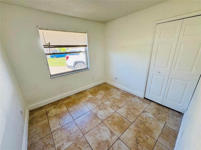 unfurnished bedroom featuring a closet and baseboards