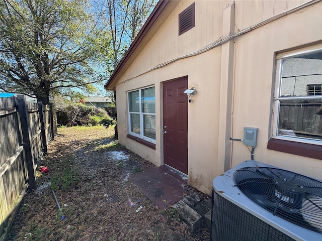 view of property exterior featuring central AC unit and fence