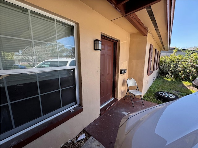 entrance to property featuring stucco siding