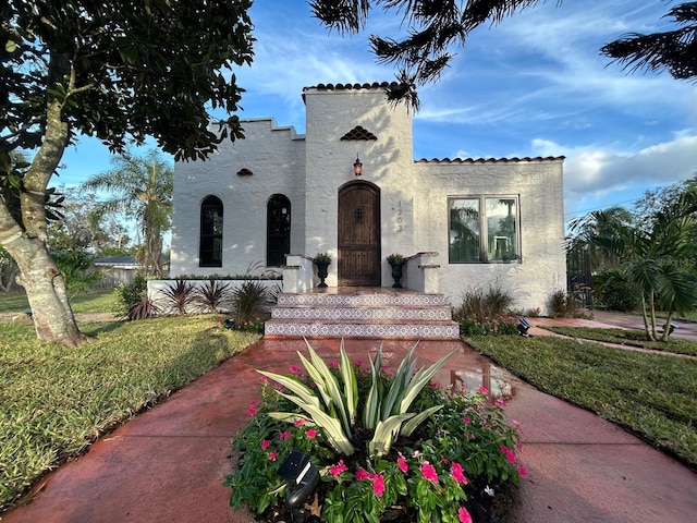 mediterranean / spanish house with a front lawn