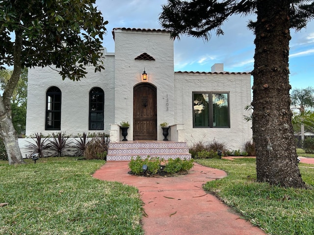 mediterranean / spanish home with a front yard