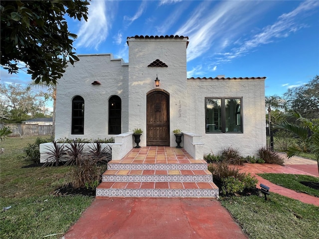 mediterranean / spanish house with a front lawn